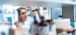 Woman looking at a solution in a beaker in the lab