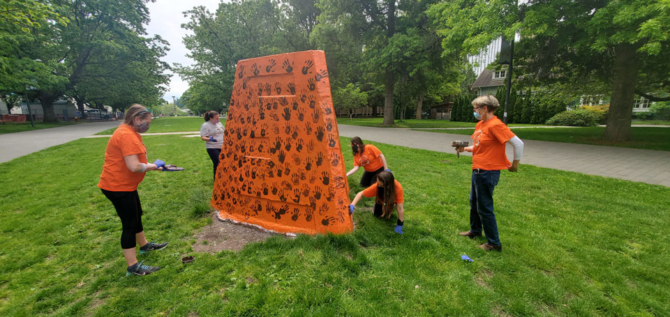 Students, faculty and staff painting the Cairn.