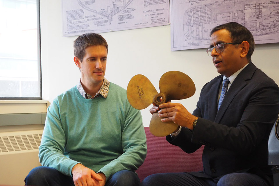 Dr. Jasmin Jelovica and Dr. Rajeev Jaiman holding and discussing about a ship propeller
