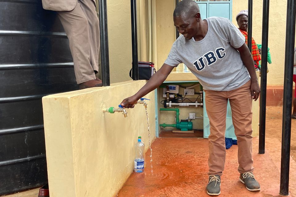 Dr. Paul Onkundi Nyangaresi pours water from a tap.