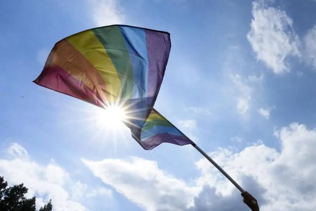 Rainbow LGBTQ pride flag waving in the sky