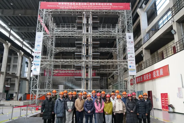 Dr. Tony Yang and team in front of the tower model, surrounded by scaffolding