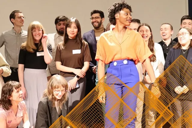 Students posing triumphantly on a stage