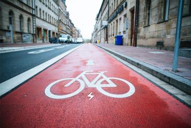 Urban Street view with a red painted bike lane clearly visible and an electric bolt icon