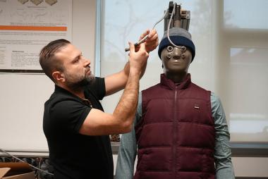 UBCO researcher Dr. Farzan Gholamreza gets Newton, a thermal manikin, ready for a sweat test in his outdoor exercise gear.