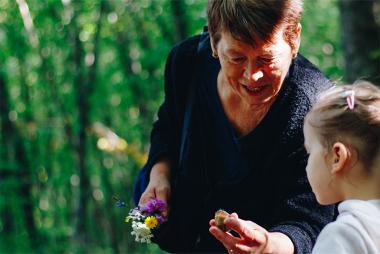 Older woman and child looking at a snail shell in hand