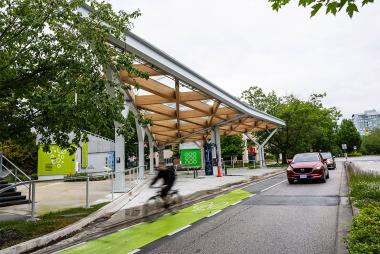 Car and cyclist passing UBC's Smart Hydrogen Energy District
