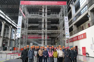 Dr. Tony Yang and team in front of the tower model, surrounded by scaffolding