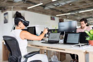 A woman using VR equipment at her desk