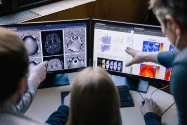 Researchers looking at brain scans on computer screen