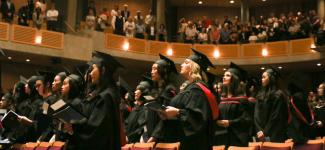 Graduates standing and clapping in the Chan Centre