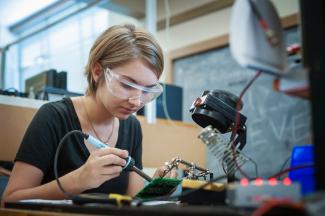 Electrical engineering student working on her circuit board