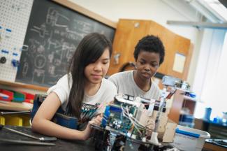 Two UBC Engineering Physics students preparing for the annual summer robot competition.