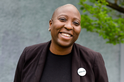 A headshot photo of Anthonia Ogundele, centered, as she smiles at the camera.