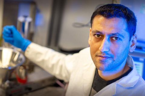 Dr. Mohammad Arjmand working in a lab, looking at camera