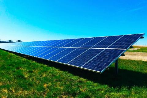 A row of solar panels on a field.