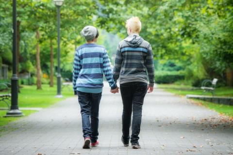 Two youths walking together, hand-in-hand