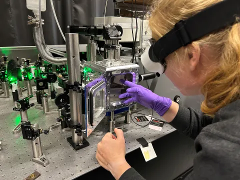 Christina Hofer places a sample into a device in a lab
