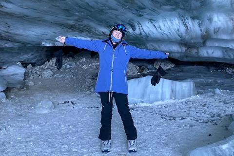 UBC Integrated Engineering graduate Darci May Nesbitt smiles for camera while bundled in cold weather outerwear and standing outside an ice cave