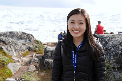 Stephanie Quon, smiling in front of ocean and rocky hills