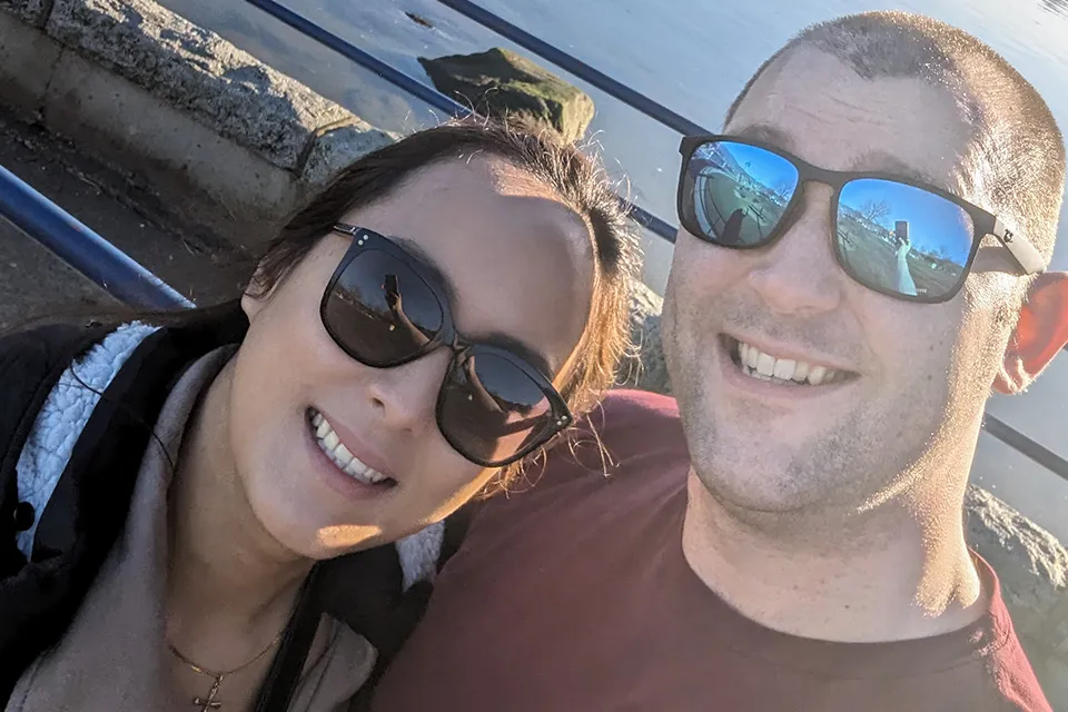 A UBC student and friend pose for a selfie on the waterfront. Both are wearing sunglasses.