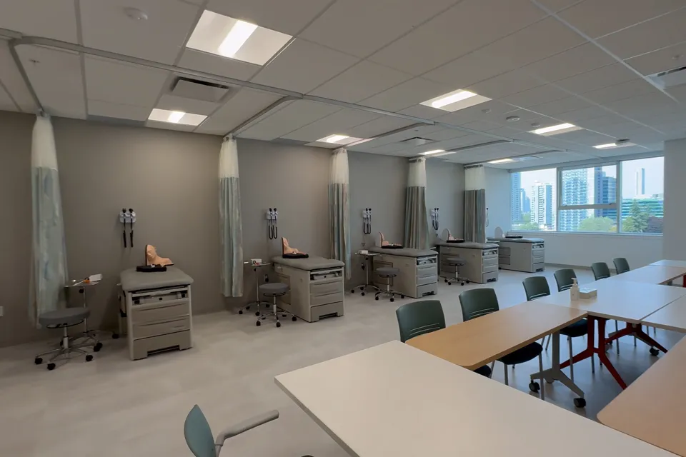 Several medical beds lined up, each with a training dummy on top. 