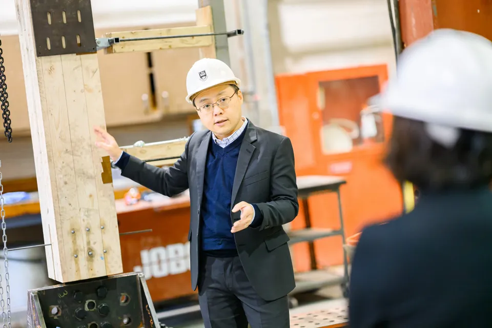 Tony Yang points to a beam in his lab
